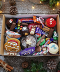 Hannah's Kitchen Christmas selection box filled with festive treats including cupcakes, gingerbread, chocolates, and candy canes, styled on a rustic wooden table with holiday decorations