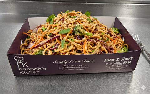 Asian-style noodle salad with broccoli, carrots, red cabbage, and sesame seeds in Hannah’s Kitchen catering tray – fresh Cork catering dish
