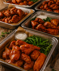 Buffalo chicken wings in catering trays with fresh rocket leaves and dip from Hannah’s Kitchen Cork.