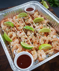 Catering tray of prawn skewers with lime wedges and chili dipping sauce, ready for events – Hannah’s Kitchen catering Cork