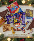 Festive Late Late Toy Show Treat Box from Hannah’s Kitchen featuring Tayto crisps, Cadbury chocolates, Nutella, brownies, blondies, and Christmas sweets surrounded by holiday decorations.